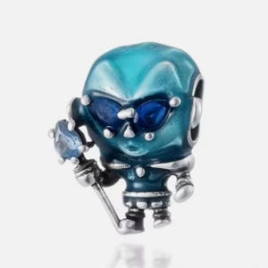 May include: A silver charm bead shaped like a stylized alien figure with a teal-colored head and body. The figure features dark blue inset eyes and holds a silver staff topped with a single, light blue, faceted gemstone accent.