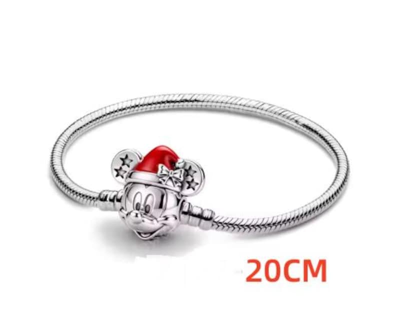 May include: A silver bracelet with a Mickey Mouse charm wearing a red Santa hat. The bracelet is 20cm long.