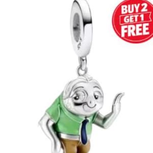 May include: A silver charm featuring a cartoon sloth wearing a green shirt, brown pants, and a blue tie. The sloth is smiling and waving. The charm has a loop at the top for attaching to a bracelet or necklace. A red circle with the text "BUY 2 GET 1 FREE" is in the upper right corner.