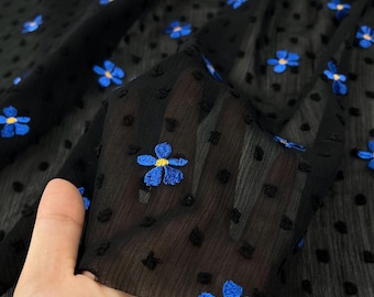 Tela de crepé de gasa bordada con flores en azul y negro, material de diseño con caída suave.