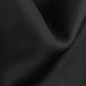 Peut inclure: Gros plan sur un tissu noir à la surface douce et texturée. Le matériau a un léger éclat et semble drapé, créant des ombres et des reflets. La texture du tissu suggère un toucher moelleux ou velouté, adapté aux vêtements ou à la décoration intérieure.