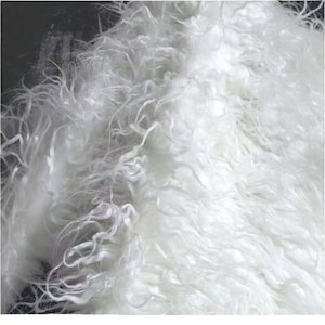 May include: Close-up of a white, fluffy textile with a curly, textured appearance. The material has a soft, cloud-like quality, with strands of varying lengths and thicknesses. The overall effect is a dense, voluminous fabric.
