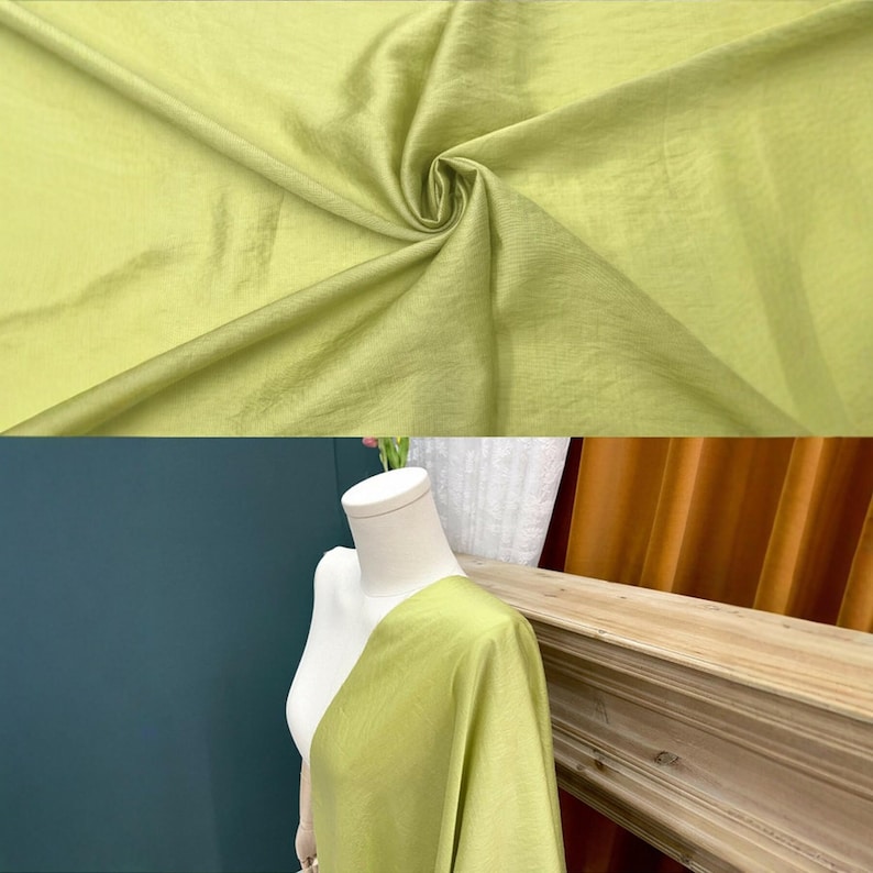 May include: A length of light lime green fabric with a subtle sheen and fine, horizontal texture. The material is shown draped in soft folds at the top and displayed on a white mannequin torso at the bottom, highlighting its smooth, lightweight drape.