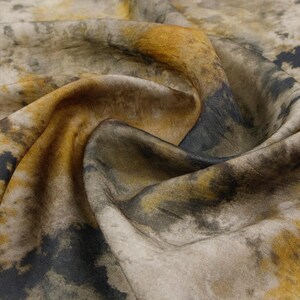 Peut inclure: Un morceau de tissu pr&eacute;sentant un motif abstrait avec des nuances m&eacute;lang&eacute;es de jaune moutarde, de gris anthracite et de blanc cass&eacute;. Le mat&eacute;riau a une texture douce et drap&eacute;e avec des plis visibles qui cr&eacute;ent de la profondeur et soulignent.