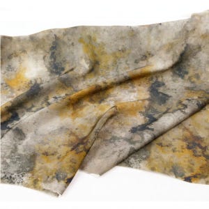 Peut inclure: Un morceau de tissu pr&eacute;sentant un motif abstrait et tachet&eacute; dans des tons de jaune moutarde, gris anthracite et blanc cass&eacute;. Le textile affiche une texture douce et pliss&eacute;e avec des taches de couleur irr&eacute;guli&egrave;res cr&eacute;ant un aspect nuageux.