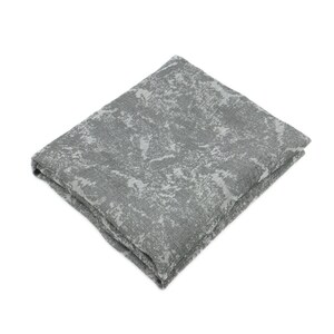 May include: Folded gray blanket with a textured, abstract pattern. The blanket is a medium gray color with lighter gray accents, creating a mottled appearance. The fabric appears soft and plush, suitable for home decor.