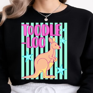 Puede incluir: Sudadera negra con un gráfico de canguro y el texto "TOODLE LOO" en rosa. El canguro es de color melocotón, sobre un fondo de rayas turquesas y negras con estrellas azules. Un diseño casual y divertido.