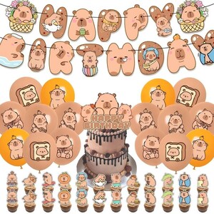 May include: A birthday party decoration set featuring capybara-themed items including a banner spelling HAPPY BIRTHDAY, numerous balloons with capybara illustrations, and cupcake toppers. A two-tier cake with chocolate frosting is centered.