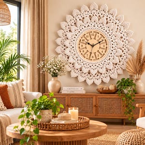 Pode incluir: Um grande relógio de parede com um mostrador circular de madeira clara com números e ponteiros pretos, rodeado por uma intrincada borda de macramé em camadas na cor off-white com um design pontiagudo em estrela que irradia do centro.