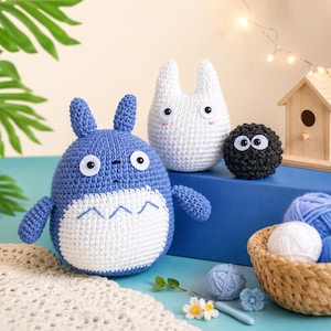 May include: Handmade crochet plush toys in the shape of characters from a popular animated film. The blue character has a white belly and the white character has long ears. A small black plush with large eyes is also present.