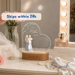May include: A heart-shaped acrylic plaque with a wooden base, featuring an illustration of two people and the text 'To My Mother On My Wedding Day'. The plaque includes a heartfelt message, the name 'Nicole', and the date '12 December 2026'.