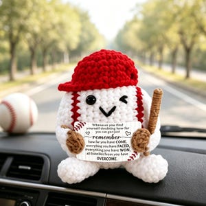 Puede incluir: Un peluche de béisbol tejido a ganchillo en blanco con una gorra roja, sosteniendo un bate marrón y un pequeño cartel que dice: Whenever you find yourself doubting how far you can go just remember how far you have COME, everything you have FACED, everything you have WON, all the battles you have OVERCOME.