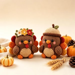 May include: Two crocheted turkey figurines featuring brown bodies, light tan bellies, and orange feet. One turkey wears a floral crown, while the other wears an acorn-shaped hat. Both have black eyes, pink cheeks, and red wattles with colorful tail feathers.