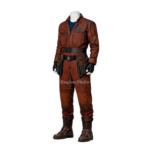 May include: A brown jumpsuit with a blue undershirt, black gloves, and a black belt with pouches. The jumpsuit has a textured pattern on the lower legs and is worn with brown boots. The text "EnginePkCo" is visible.