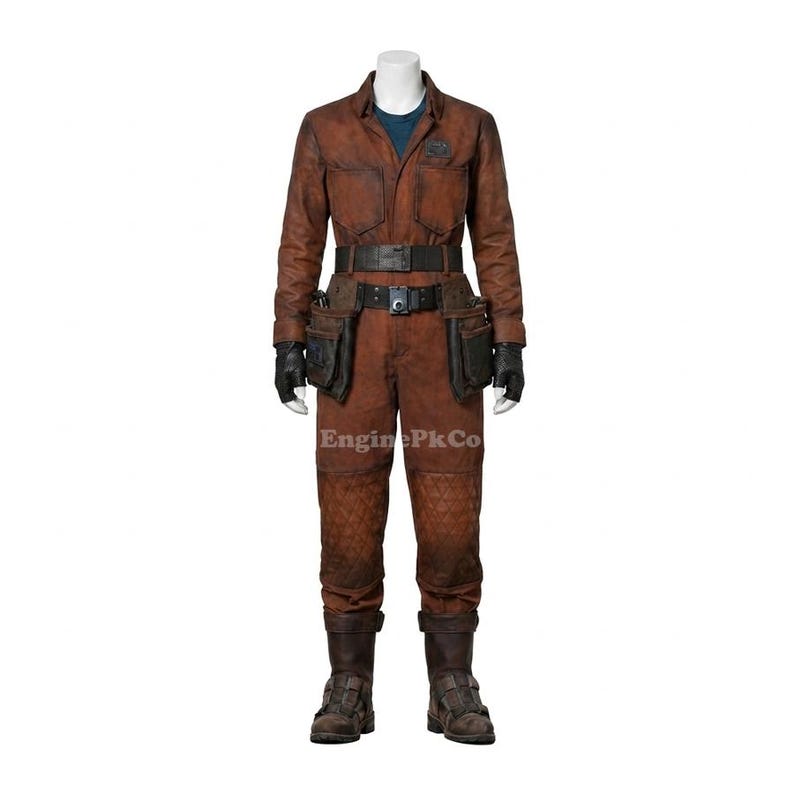May include: A brown jumpsuit with a matching belt, tool pockets, and boots. The outfit has a textured appearance and is worn with black gloves. The jumpsuit has a blue undershirt and a small patch on the chest. The text "EnginePkCo" is visible.