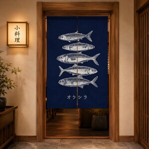 Può includere: Una tenda giapponese noren blu navy con illustrazioni di pesci bianchi. La tenda è appesa in una porta di legno. Il testo giapponese "小料理" è su un'insegna luminosa a sinistra.