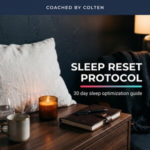 Może przedstawiać: Cyfrowy przewodnik zatytułowany SLEEP RESET PROTOCOL 30 day sleep optimization guide od COACHED BY COLTEN. Obraz przedstawia ciemnobrązowy notatnik z czarnym długopisem, zapaloną bursztynową świecę i biały kubek na drewnianej powierzchni obok białej poduszki.