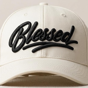 Puede incluir: Gorra de béisbol color crema con la palabra "Blessed" bordada en negro en la parte delantera. La gorra tiene una visera curva y un botón en la parte superior. Un accesorio sencillo y elegante.