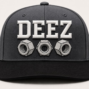 May include: A dark gray baseball cap with a flat black brim. The front features the white embroidered text DEEZ positioned above three silver-toned hexagonal metal nuts arranged in a horizontal row across the center of the crown.