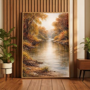 May include: A framed landscape painting depicts a serene river scene. The artwork features a river flowing through a forest with trees in autumn colors. The painting is in a wooden frame and is displayed indoors.