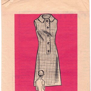 May include: A vintage sewing pattern for a sleeveless dress with a button-up front. The pattern is printed on a pink background and includes the text "Printed Pattern 9069 - SIZE 12 1/2".