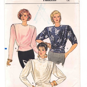 Può includere: Modello di cucito Vogue Patterns numero 9751 per la taglia 12. Il modello presenta tre diversi stili di bluse con maniche a sbuffo. Le bluse sono mostrate su tre modelli che indossano colori e motivi diversi.