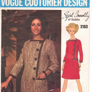 Peut inclure: Un patron de couture vintage présentant un modèle de robe de Sybil Connolly de Dublin. Le numéro du patron est 2183. La robe est rouge avec des finitions noires et a des manches longues. Le mannequin porte la robe et a les cheveux courts bruns. Le patron est sur un fond blanc avec un logo Vogue Couturier Design bleu et blanc.