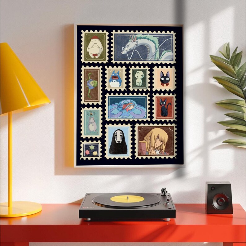 May include: A framed art print featuring a collection of postage stamp-style illustrations of characters from animated films. The stamps are arranged on a black background and framed in a light wood frame. The illustrations include a dragon, a cat, and other whimsical figures.