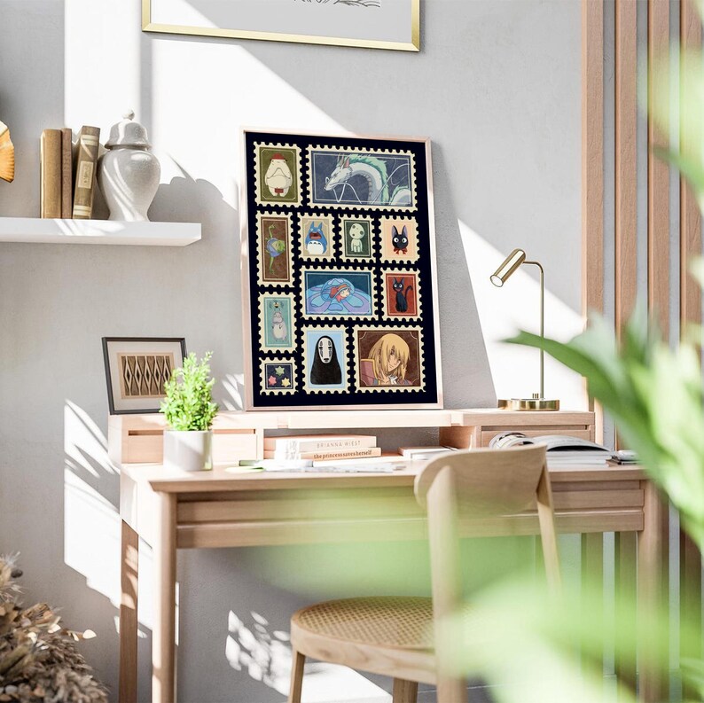 May include: A framed print featuring a collection of postage stamp-style illustrations of characters from a popular animated film. The artwork is displayed on a wooden desk with a small lamp and a chair. The print is in a light-colored wooden frame.