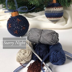 May include: Handmade Christmas baubles with a starry night theme. The baubles are navy blue and embellished with copper-coloured stars. The image also shows grey, navy, and beige yarn, a crochet hook, and the text "Starry Night".