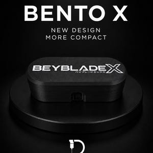 Può includere: Un contenitore nero di forma ovale con la scritta BEYBLADE X sul coperchio. Il testo sopra recita BLACK SERIES, BENTO X, NEW DESIGN, MORE COMPACT. Sotto il contenitore si trova il logo D.LAB STUDIO con la scritta 3D PRINTING & CAD DESIGN.