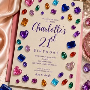 May include: A cream-colored birthday invitation card featuring purple text and scattered colorful faux gemstones in various shapes like hearts, ovals, and rectangles. The text reads: Please join us to celebrate Charlotte's 21st birthday, Saturday 26 July 2026, 7:30pm, The Gem Room, 123 Party Lane Chicago, IL, RSVP by 12 July Charlotte 123-555-456, dress to dazzle.