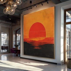 Puede incluir: Gran obra de arte rectangular que representa una escena de puesta de sol. La obra presenta un sol naranja y rojo vibrante que domina la parte superior, con un paisaje oscuro y texturizado debajo. La pieza está enmarcada en un borde dorado y cuelga de una pared clara.