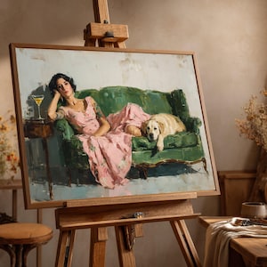 May include: A framed painting on an easel shows a woman in a pink floral dress reclining on a green sofa with a golden retriever. A cocktail sits on a side table. The artwork has a vintage aesthetic.