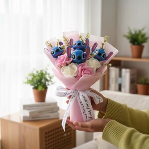 May include: A bouquet featuring blue character figures with large ears, pink and white roses, and greenery, wrapped in pink paper and tied with a white ribbon. The ribbon reads "Just for you."