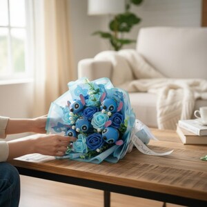 May include: A bouquet of blue and light blue flowers and character figures wrapped in blue cellophane. The bouquet is tied with a white ribbon. The bouquet is on a wooden table.
