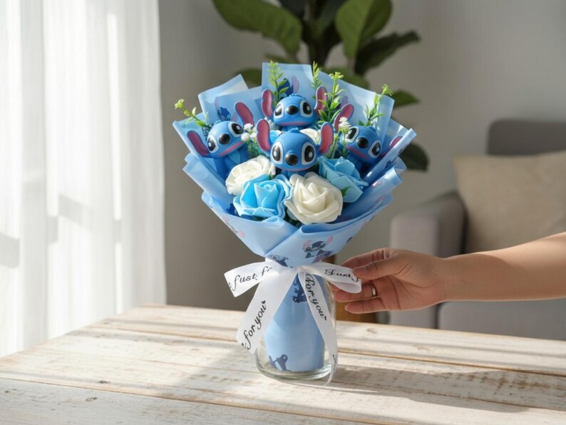Pu&ograve; includere: Un bouquet con personaggi blu dei cartoni animati, carta blu e bianca e rose bianche e blu. Il bouquet &egrave; avvolto con un nastro blu con la scritta "For you". Il bouquet &egrave; in un vaso di vetro trasparente.