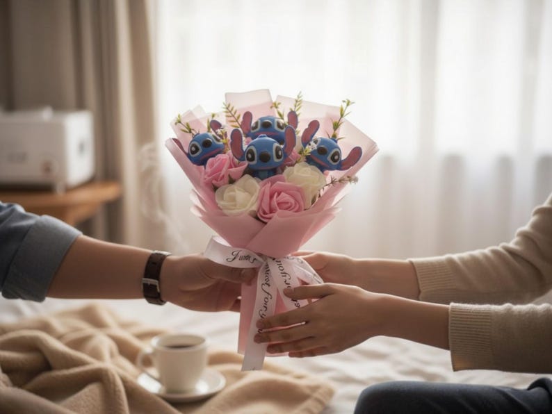 May include: A bouquet featuring blue Stitch plush toys, pink and white roses, and greenery, wrapped in pink paper and tied with a ribbon that says "I love you".