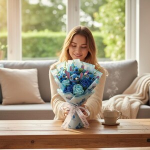 May include: A bouquet of blue and light blue flowers, including roses and character figures, wrapped in patterned paper and tied with a ribbon. The bouquet is held by a person in a cream-colored sweater. A coffee cup sits on a wooden table.