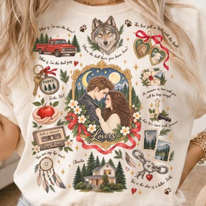 May include: A cream-colored t-shirt featuring a collage of illustrations including a red truck, a wolf, a heart-shaped locket, a cassette tape, a house, and a central portrait of a couple framed in gold with the text Lovers.
