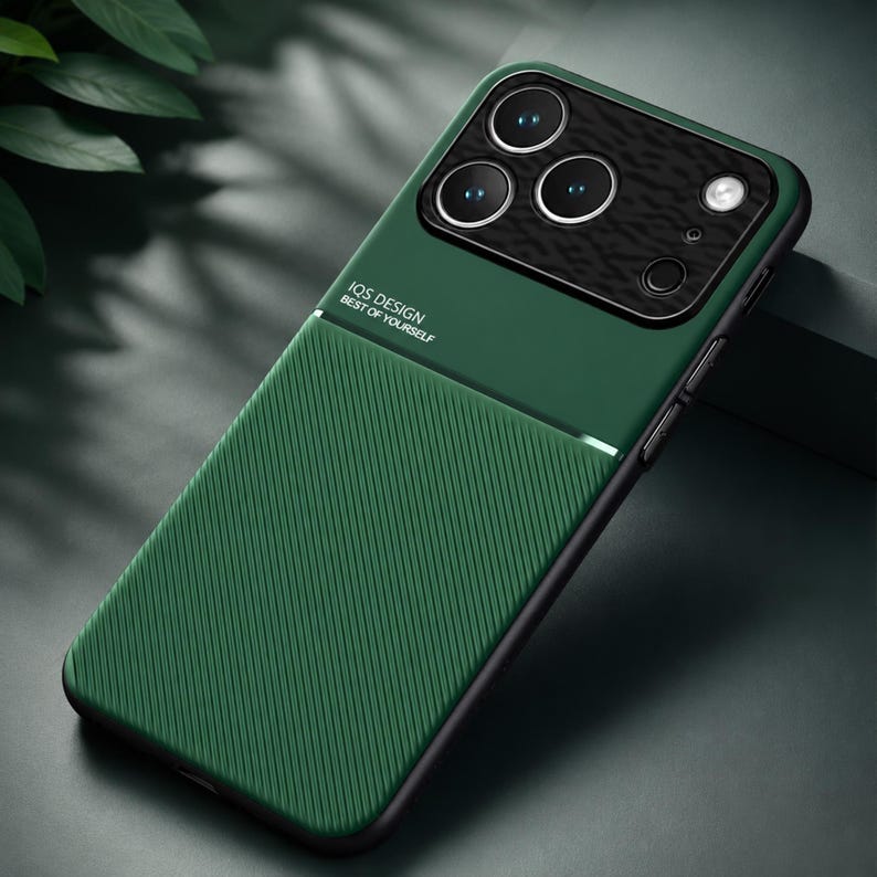 May include: Green phone case with a textured back and a black camera module. The case has the text "IQS DESIGN BEST OF YOURSELF" printed on it. The case is designed to protect the phone from scratches and damage.