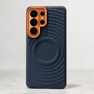 Puede incluir: Una funda para smartphone de color azul marino oscuro con una superficie texturizada que presenta ondas circulares concéntricas. La funda incluye un marco naranja prominente y elevado alrededor del módulo de cámara con cuatro lentes negras.