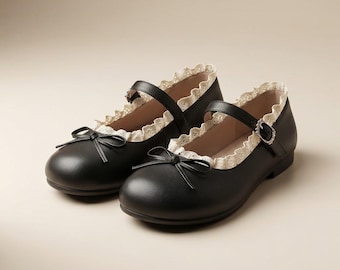 May include: A pair of black Mary Jane shoes featuring a rounded toe, a thin adjustable strap with a silver-toned buckle, a decorative black bow on the front, and a cream-colored scalloped lace trim along the top edge of the shoe opening.