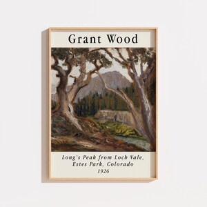 May include: A framed art print featuring a landscape painting by Grant Wood titled Long's Peak from Loch Vale, Estes Park, Colorado, 1926. The image depicts gnarled trees in the foreground with a mountain peak and forest in the background.