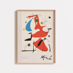 Pode incluir: Uma impressão de arte emoldurada com uma composição abstrata de Joan Miró, apresentando uma grande forma orgânica vermelha, uma meia-lua azul e elementos lineares pretos sobre um fundo creme. O texto "HOMMAGE A JOAN MIRO" e "JOAN MIRO 1973" aparece no canto inferior esquerdo, com a assinatura "Miró" no canto inferior direito.