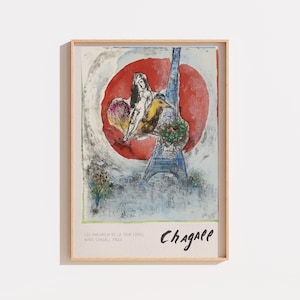 Peut inclure: Une impression d'art encadrée représentant une peinture de Marc Chagall intitulée Les Amoureux de la Tour Eiffel. L'œuvre montre un couple et un oiseau devant un grand cercle rouge et la tour Eiffel, avec le texte Chagall en bas.