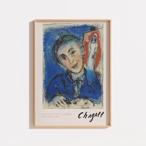 Peut inclure: Une impression d'art encadrée représentant la peinture Autour du peintre au coq rouge de Marc Chagall. L'œuvre montre une personne peignant avec une palette sur un fond bleu avec une figure de coq rouge. Le texte Chagall est inscrit en bas.