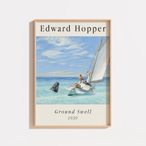 Op de afbeelding: Een ingelijste kunstdruk met het schilderij Ground Swell van Edward Hopper uit 1939. De afbeelding toont een witte zeilboot op blauw zeewater met een zwarte boei op de voorgrond en een blauwe lucht met lichte wolken. De tekst luidt Edward Hopper.
