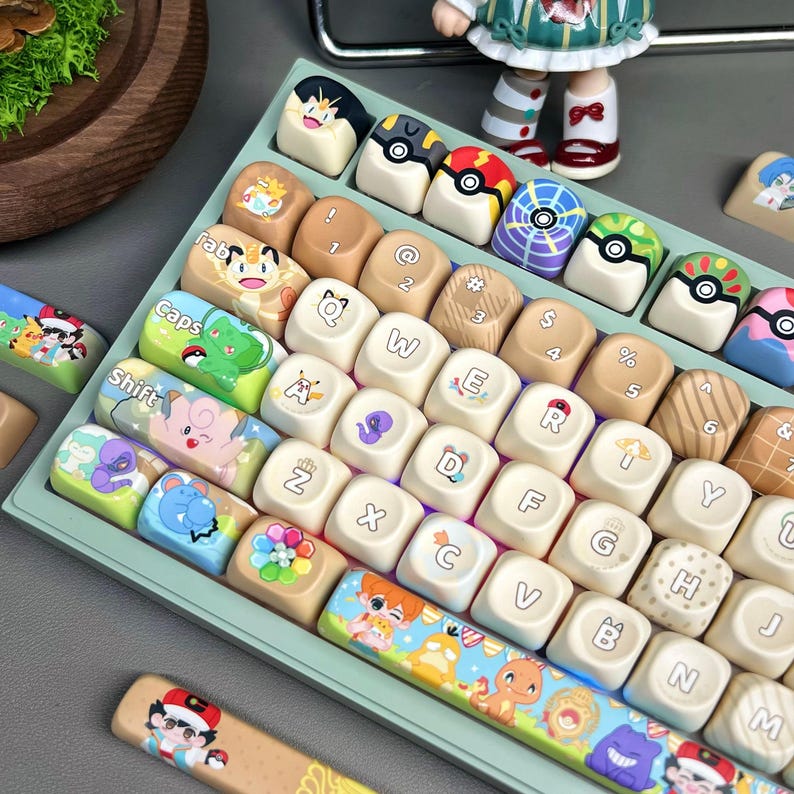May include: A custom mechanical keyboard with colorful keycaps featuring cartoon characters and designs. The keycaps have various colors, including white, tan, and green, with images of characters and symbols. The keyboard is set on a light green base.
