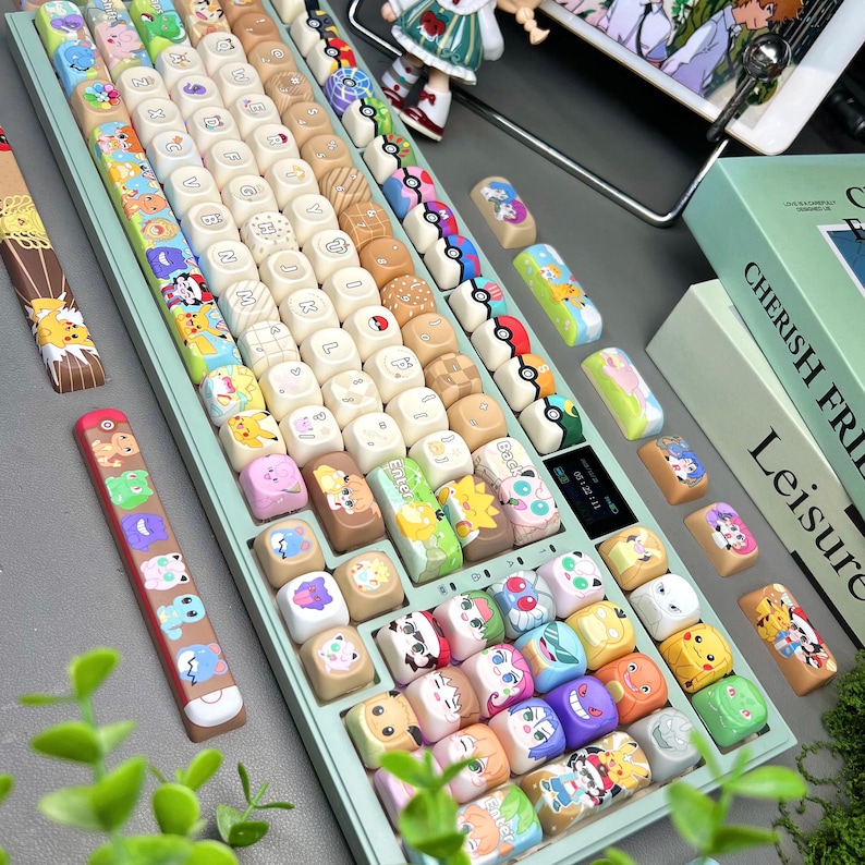 May include: A custom mechanical keyboard with a light green base and a variety of colorful keycaps. The keycaps feature cartoon characters and designs. Additional keycaps are scattered around the keyboard. The keyboard also has a small display screen.